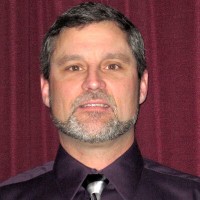 Spenser Brooks Man with short dark hair and salt and pepper beard and mustache